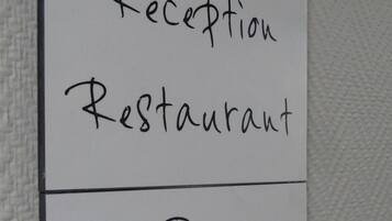 Señal con indicaciones hacia Recepción, Restaurante y Bar.