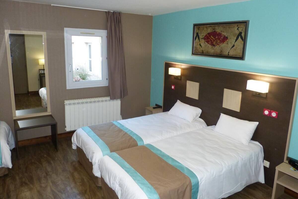 A hotel room with a double bed, a bedside table, a mirror, a window with curtains, and a painting on the wall.