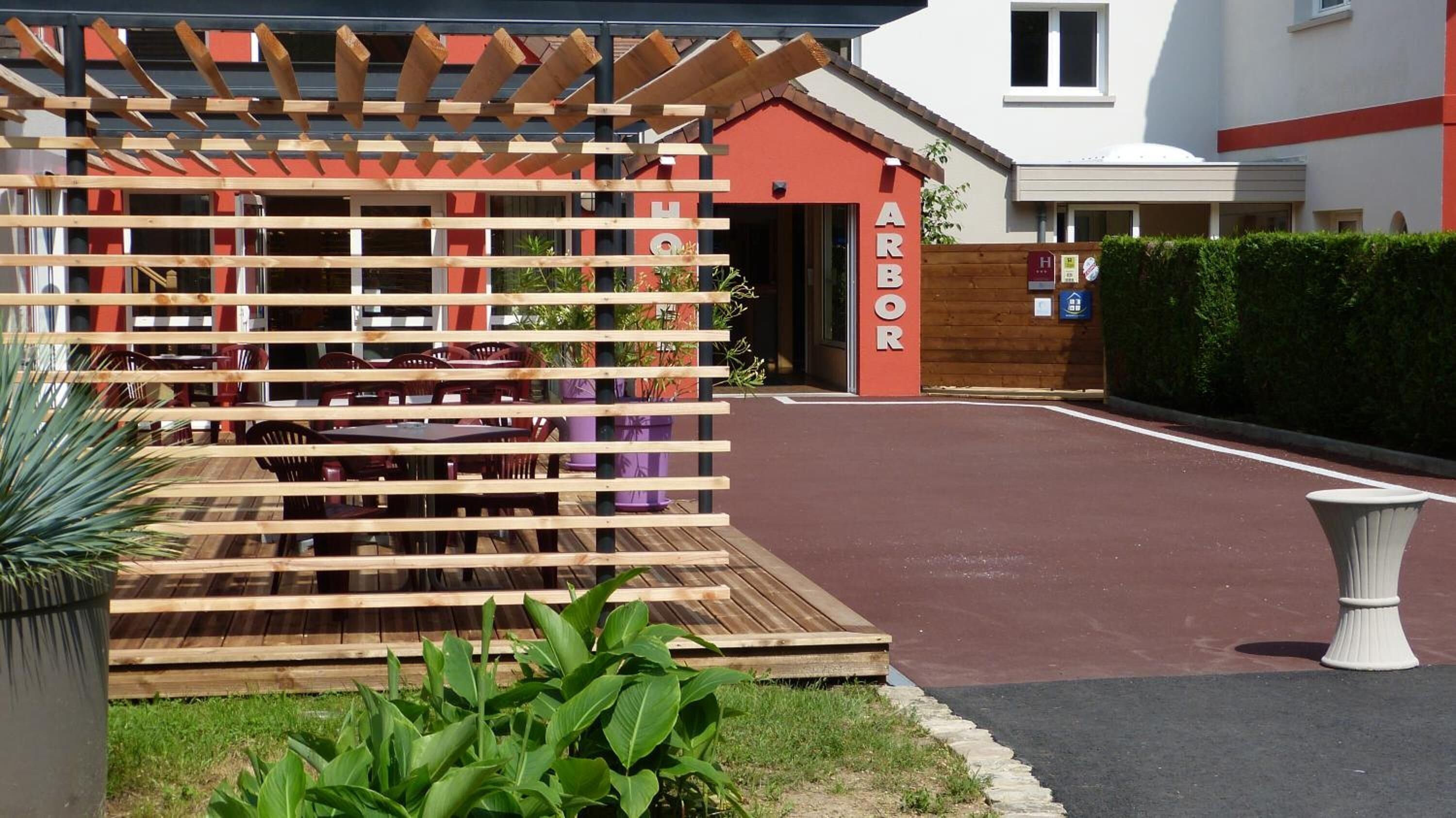 Una pérgola de madera con un letrero que dice 'HOTEL ARBOR'.