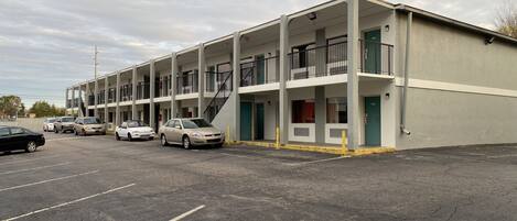 Un motel de varios pisos con estacionamiento.