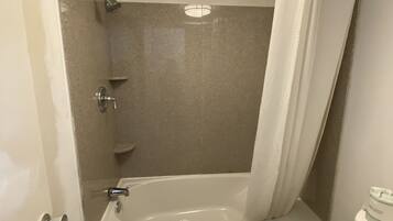 Un baño con bañera, inodoro y ducha.
