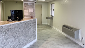 A reception area with a marble counter, a computer, and a no-smoking sign. - Red Carpet Inn & Suites (Danville)