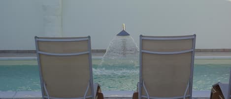 Een buitenzwembad, parasols voor strand/zwembad