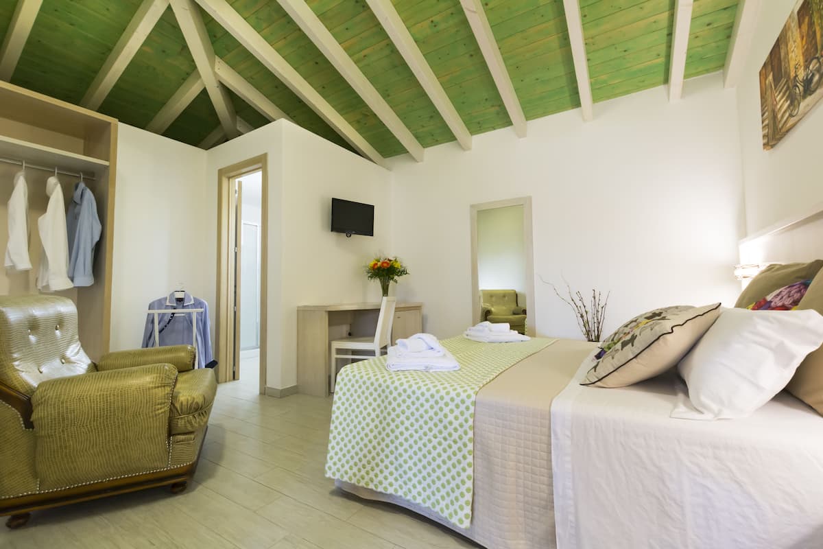 A bedroom with a bed, a desk, a chair, and a wardrobe.