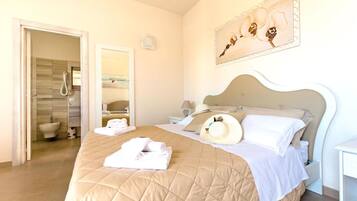 Una habitación de hotel con cama, baño y un cuadro en la pared.