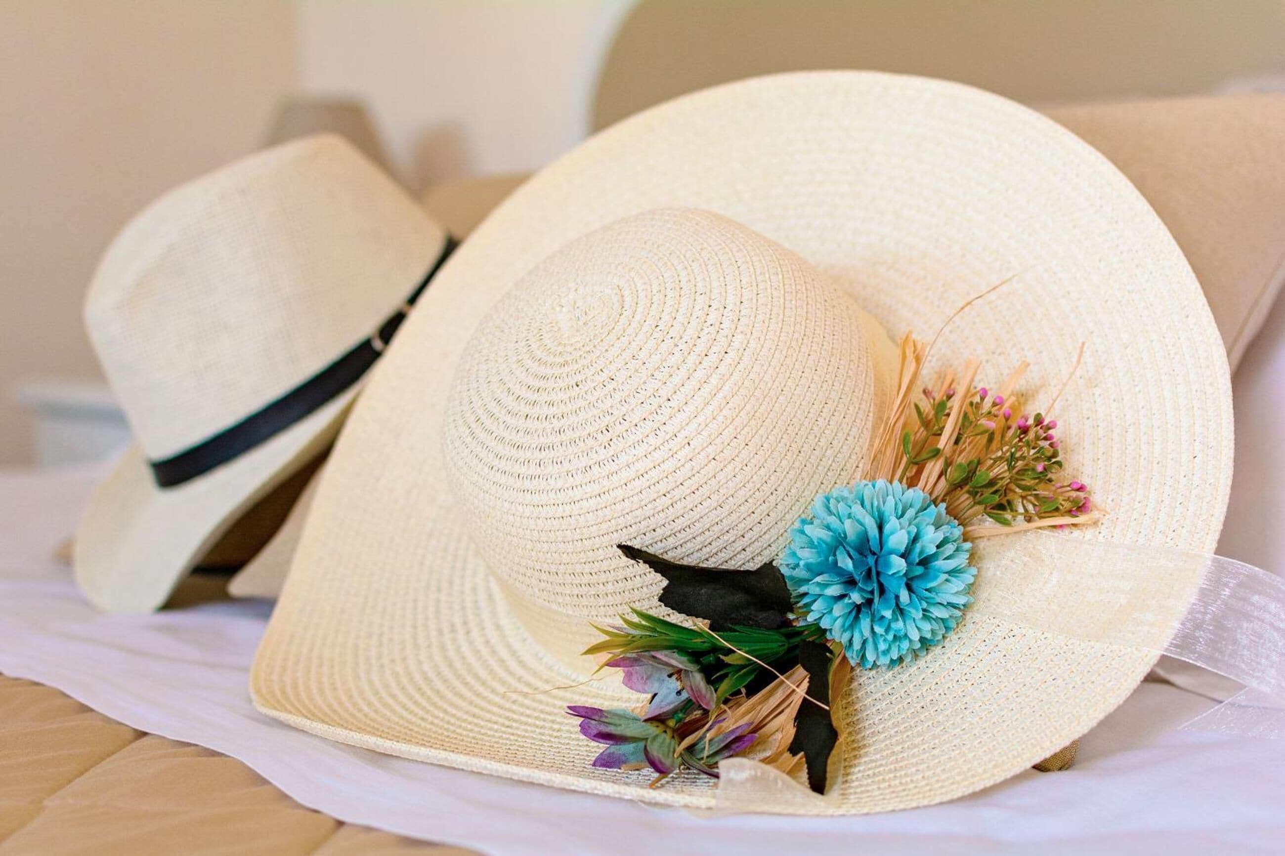 Una colección de sombreros de paja con detalles decorativos.