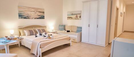 A bedroom with a bed, bedside table, lamp, and artwork on the wall.