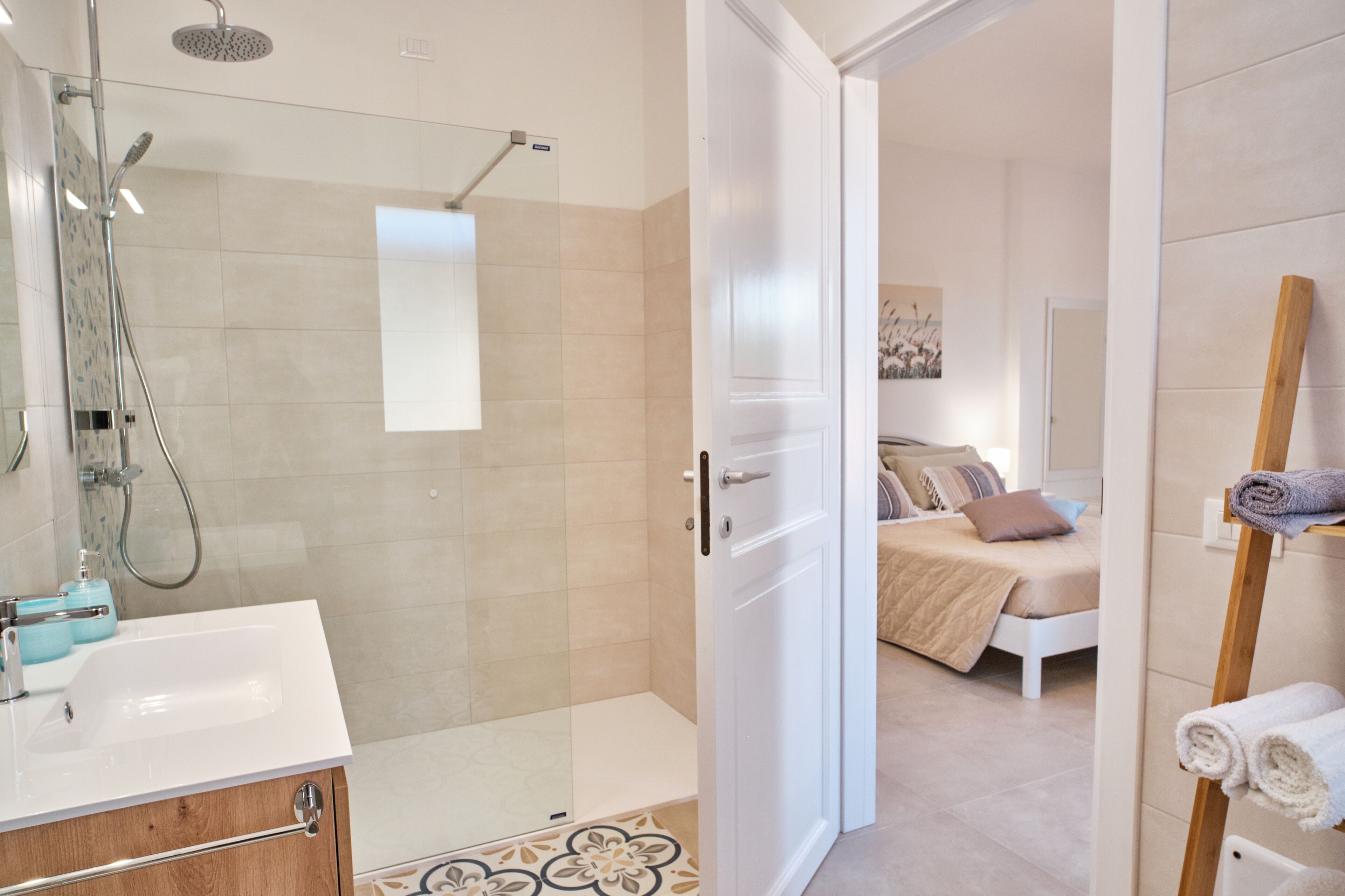 Une salle de bain moderne avec une douche à parois de verre, un lavabo blanc et un meuble en bois.