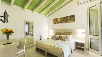 Una camera d'albergo con un letto, comodini, una scrivania, una sedia, uno specchio e un quadro appeso al muro.