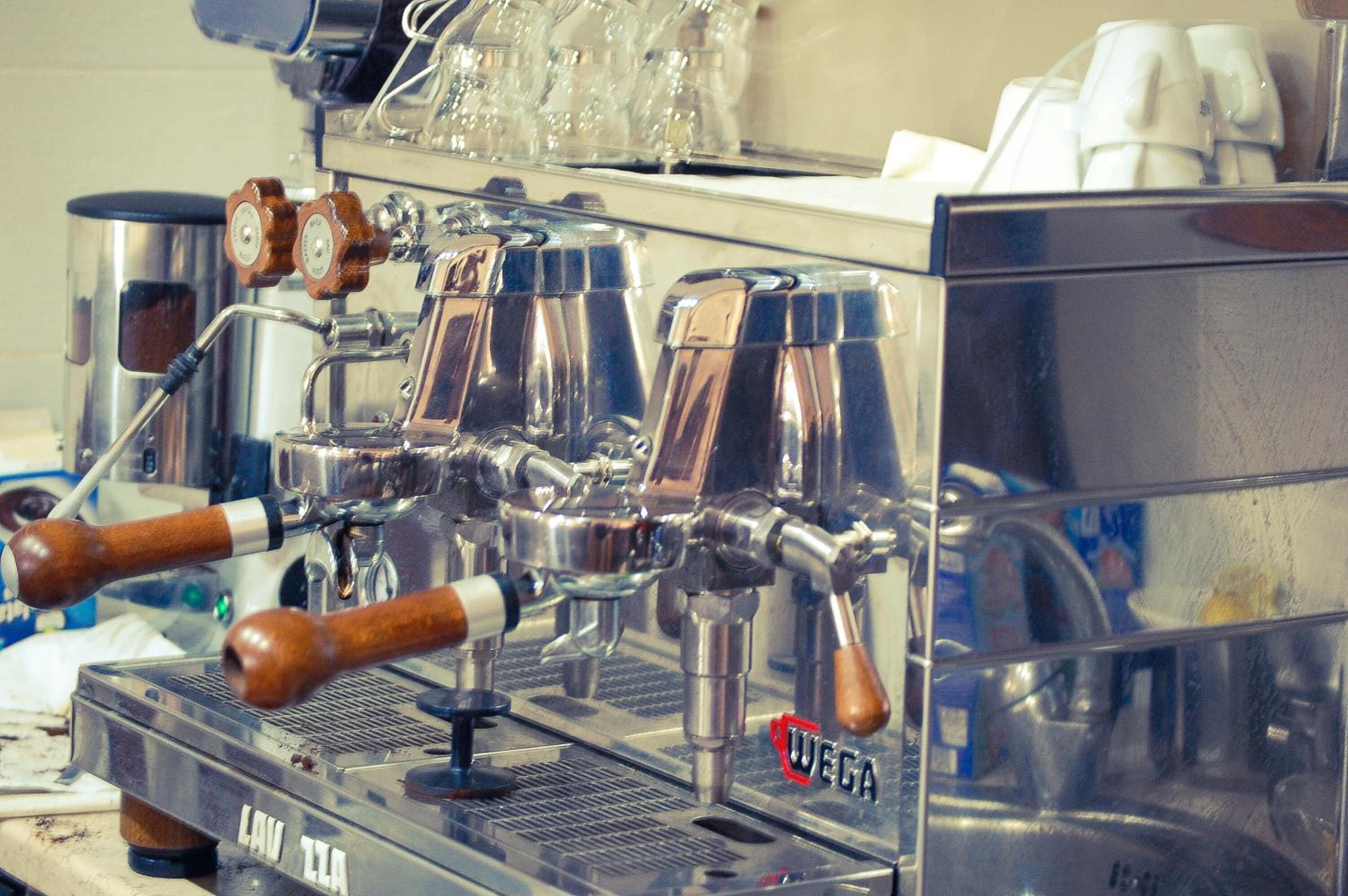 A coffee machine with multiple steam wands and a branded logo.