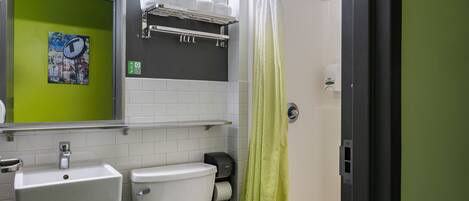 A bathroom with a toilet, sink, and shower curtain.