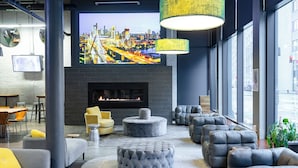 Un espace de détente moderne doté d’un grand écran de télévision, de sièges confortables et d’une cheminée.
