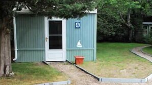 A small, single-story building with a white door and a blue number '0' sign. - HI Eastham - Hostel (Eastham)
