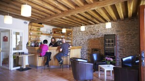 Un rústico bar con vigas de madera, paredes de piedra y asientos de cuero.