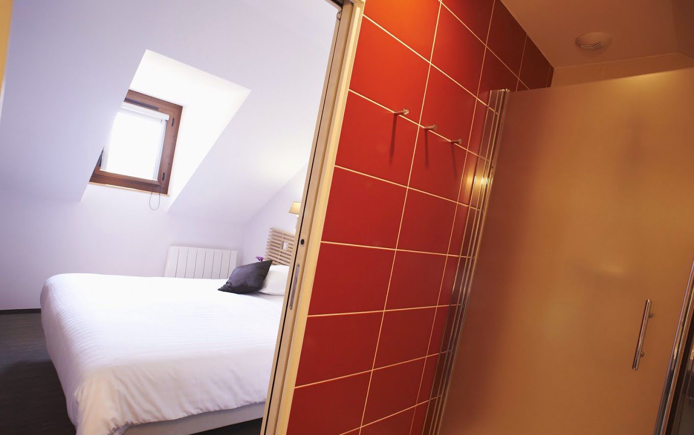 A bedroom with a bed, a window, and a wardrobe.