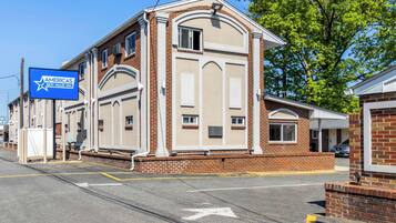 Americas Best Value Inn features a two-story building with a central entrance and symmetrical design.