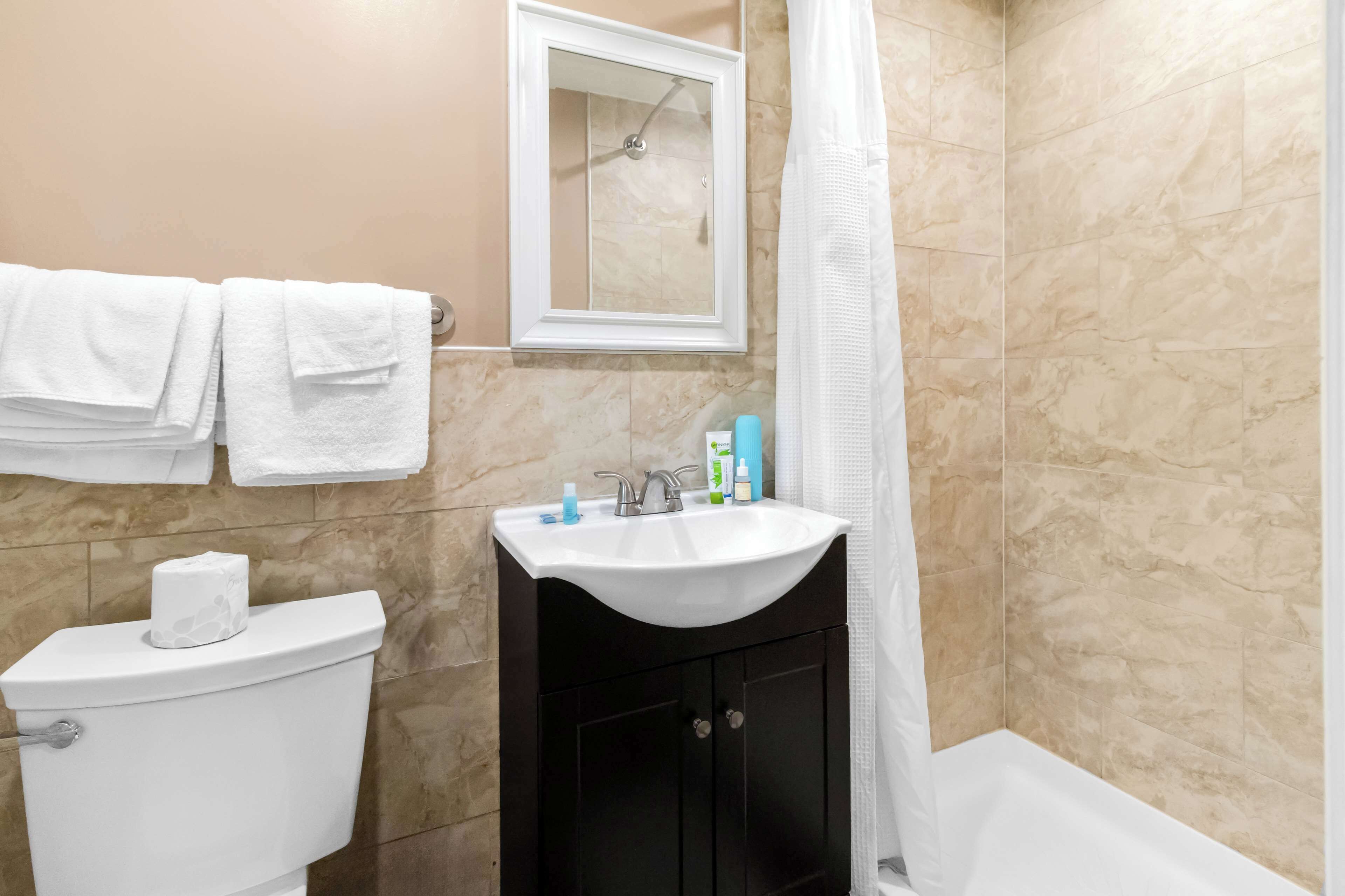 A bathroom with a toilet, sink, and shower.