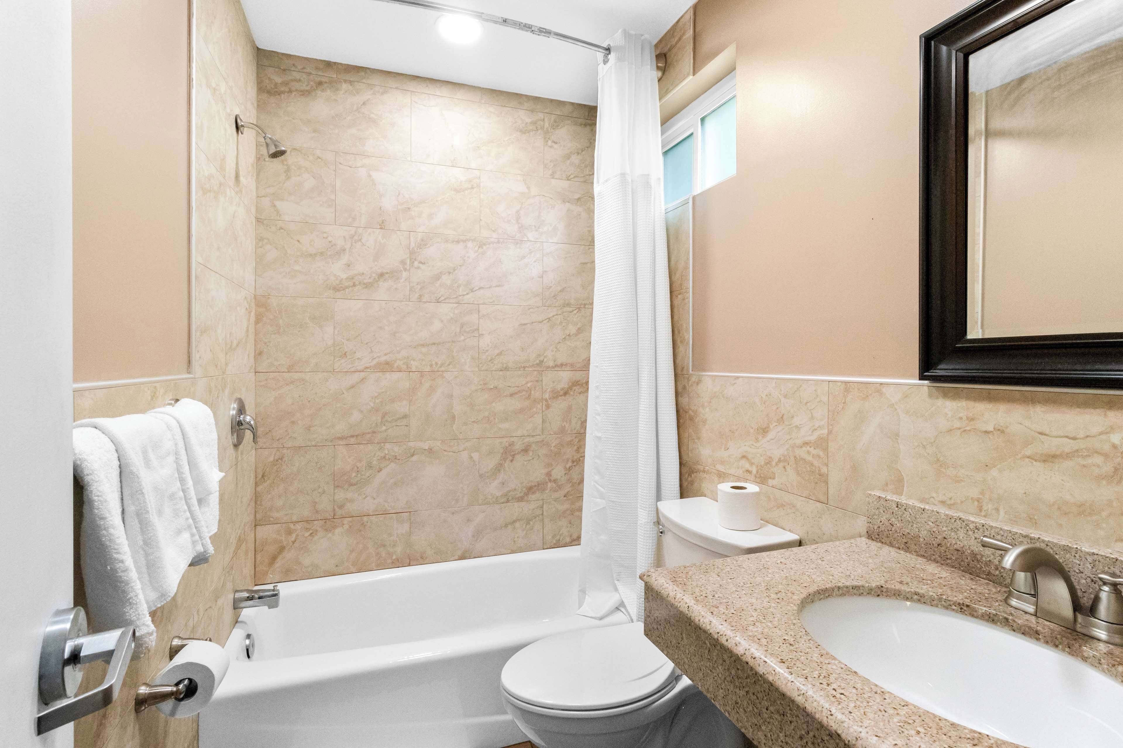 A bathroom with a bathtub, toilet, and sink.