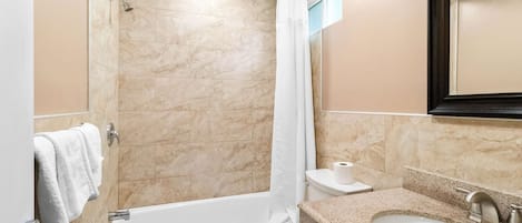 Un baño con bañera, inodoro y lavamanos.