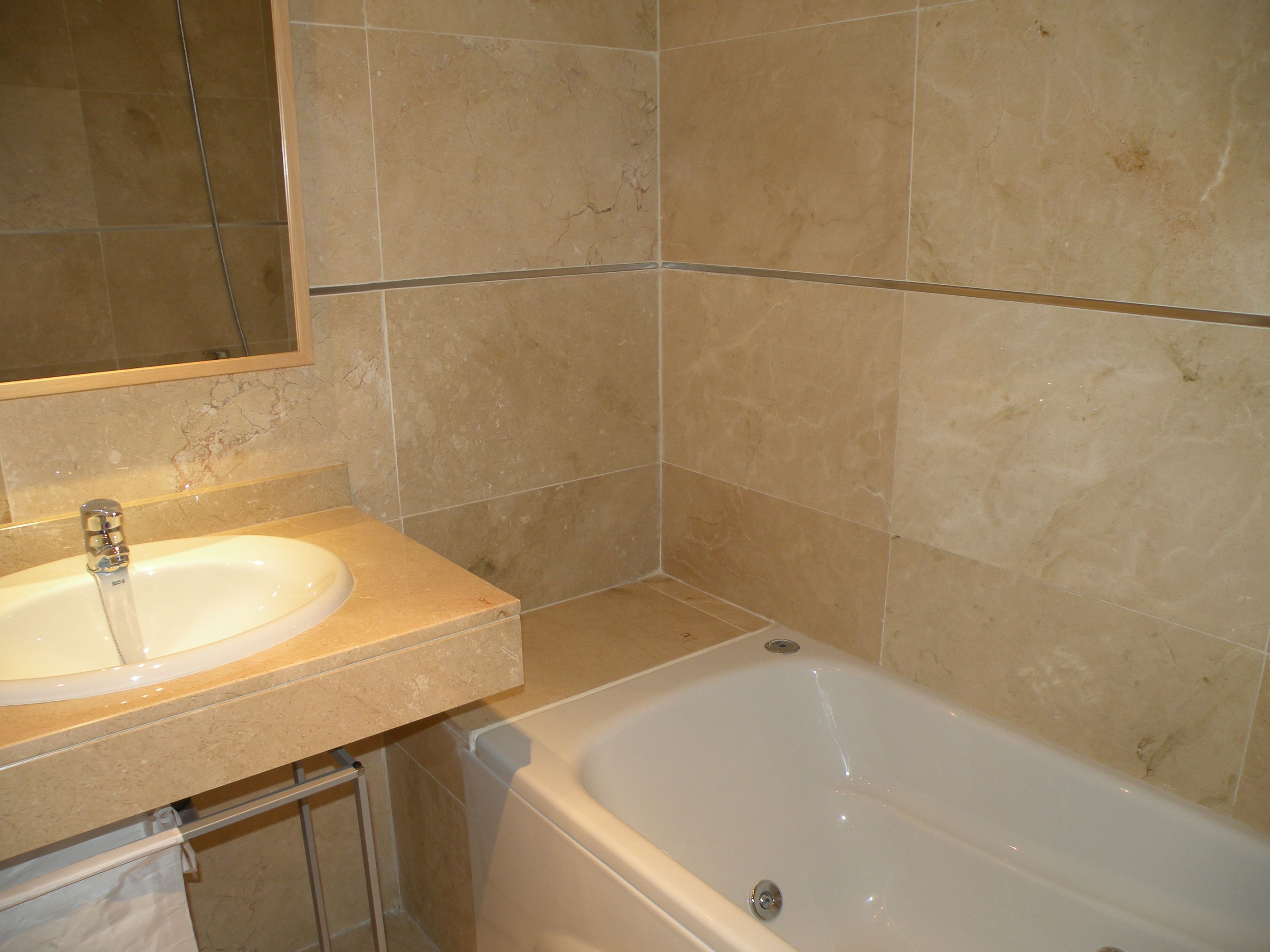 A bathroom with a sink, mirror, and bathtub.