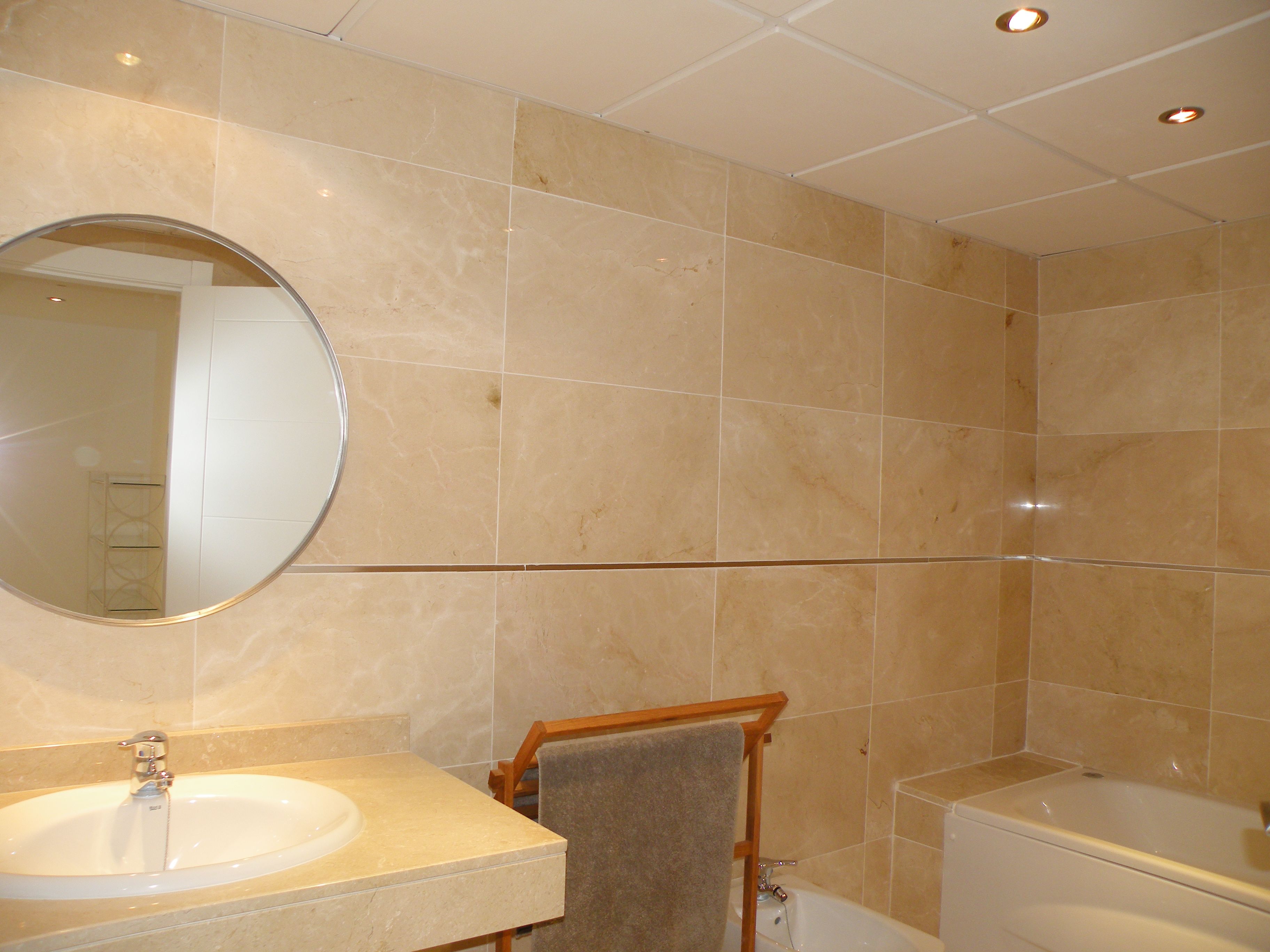 A bathroom with a sink, mirror, towel rack, and bathtub.