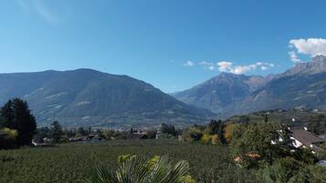 Un paisaje montañoso con un valle, casas y cielo despejado.