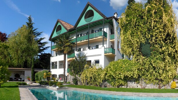 Un edificio de dos pisos con piscina delantera.