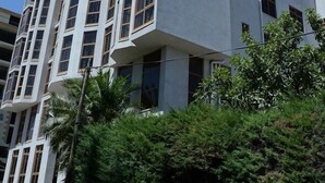 Un hotel de varios pisos con un diseño arquitectónico moderno, que destaca un letrero en la parte superior.