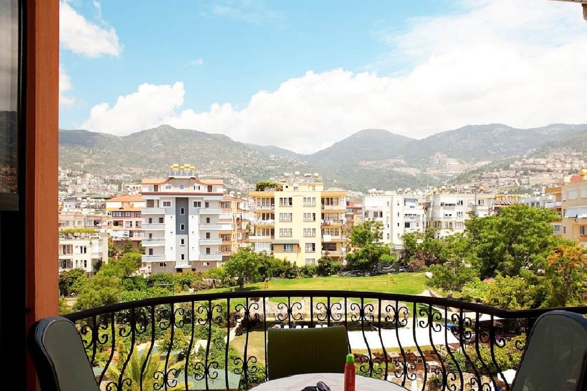 Ein Balkon mit Blick auf eine Stadtlandschaft und Berge.