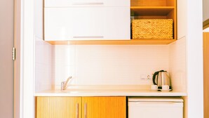 A kitchen with white cabinets, a wooden countertop, a stainless steel kettle, and a dishwasher. - Calimera Sunpark Alanya (Alanya)