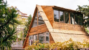 A modern wooden house with large windows and a thatched roof. - Calimera Sunpark Alanya (Alanya)