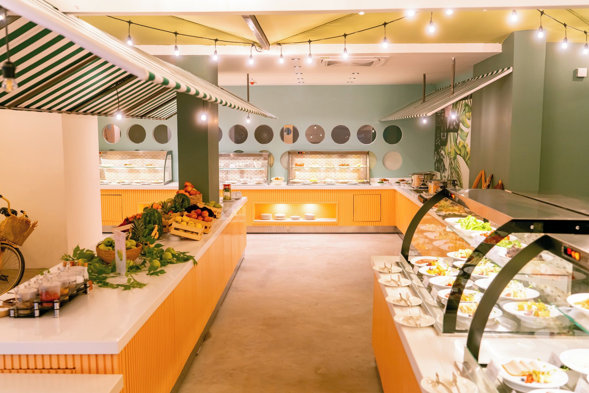 A buffet area with various food displays, a central serving counter, and a bicycle rack.