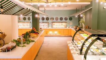 A buffet area with various food displays, a central serving counter, and a bicycle rack.
