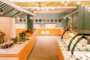 A buffet area with various food displays, a central serving counter, and a bicycle rack. - Calimera Sunpark Alanya (Alanya)