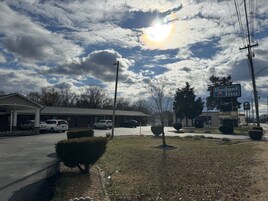 Um motel com estacionamento, placa indicando Budget Inn e um Taco Bell.