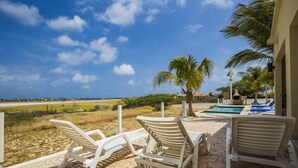 Un espace aménagé au bord de la piscine, avec des chaises longues, une piscine et une vue sur le paysage.