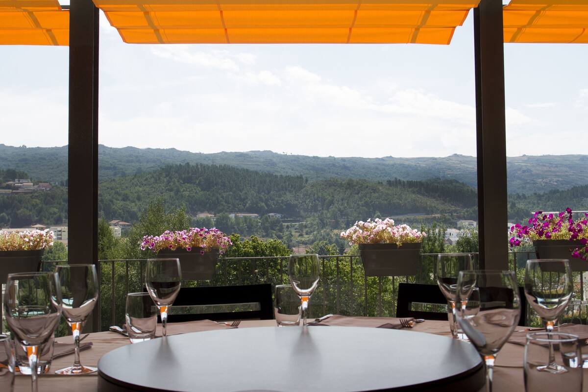 A table set for dining with a view of a mountainous landscape.