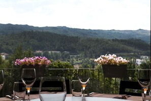 A table with empty wine glasses and a view of a mountainous landscape. - Hotel Aguiar da Pena (Vila Pouca de Aguiar)