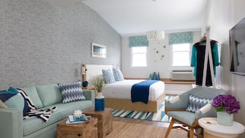 Une chambre moderne avec un grand lit, un canapé, un fauteuil et une table basse en bois.