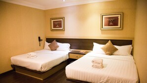 A hotel room with two beds, each with white linens and pillows, a wooden headboard, a nightstand, and a wall-mounted phone. - Valenza Hotel & Cafe (Kuala Lumpur)