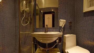 A bathroom with a white sink, a mirror above it, and a toilet.
