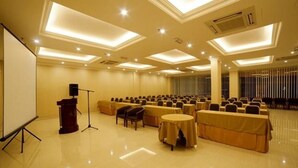 A conference room with a stage, rows of chairs, and tables. - Valenza Hotel & Cafe (Kuala Lumpur)