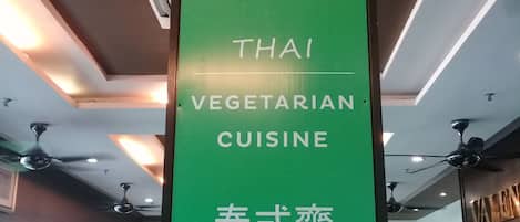 A signboard for Sukaphat Vegetarian restaurant advertising Thai vegetarian cuisine.