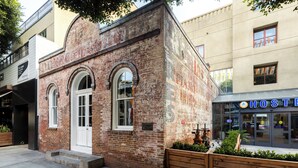 Un edificio de ladrillo con una puerta blanca y ventanas de arco.