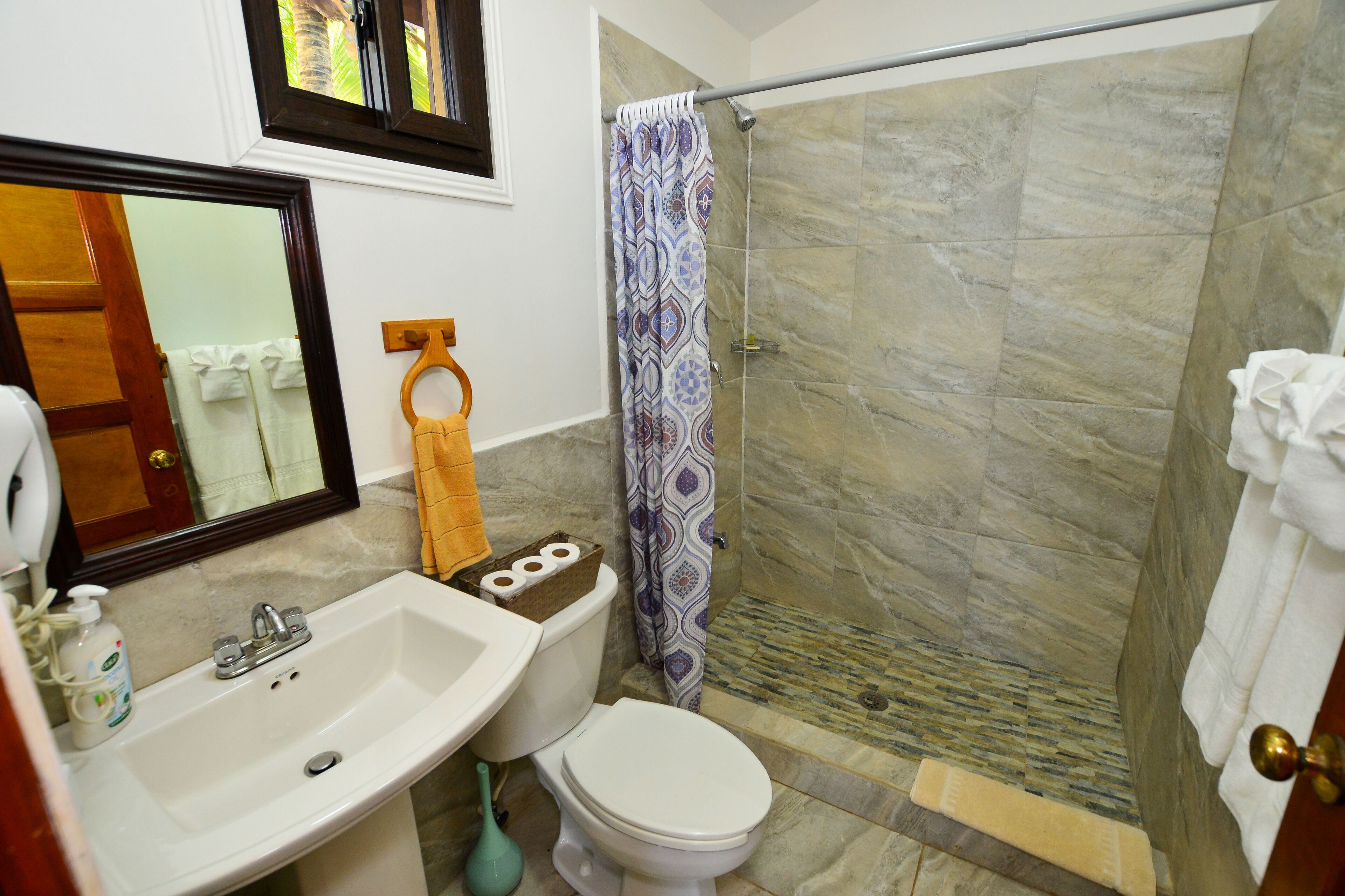 A bathroom with a sink, toilet, and shower.