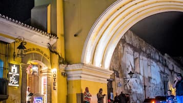 Entrada de hotel con fachada amarilla, un arco de acceso y un letrero que indica el nombre 'Hotel'.