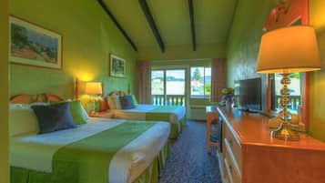 Una camera d'albergo con due letti, una scrivania, una televisione e vista sull'esterno.