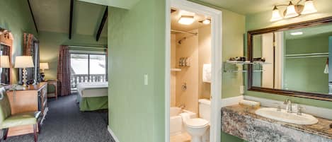 A hotel bathroom with a large mirror, sink, and shower.