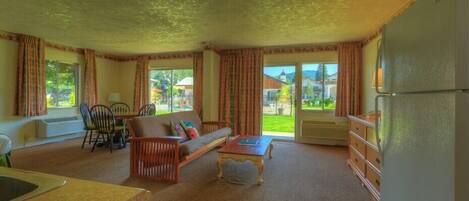 A spacious living room with a sofa, coffee table, and dining area.