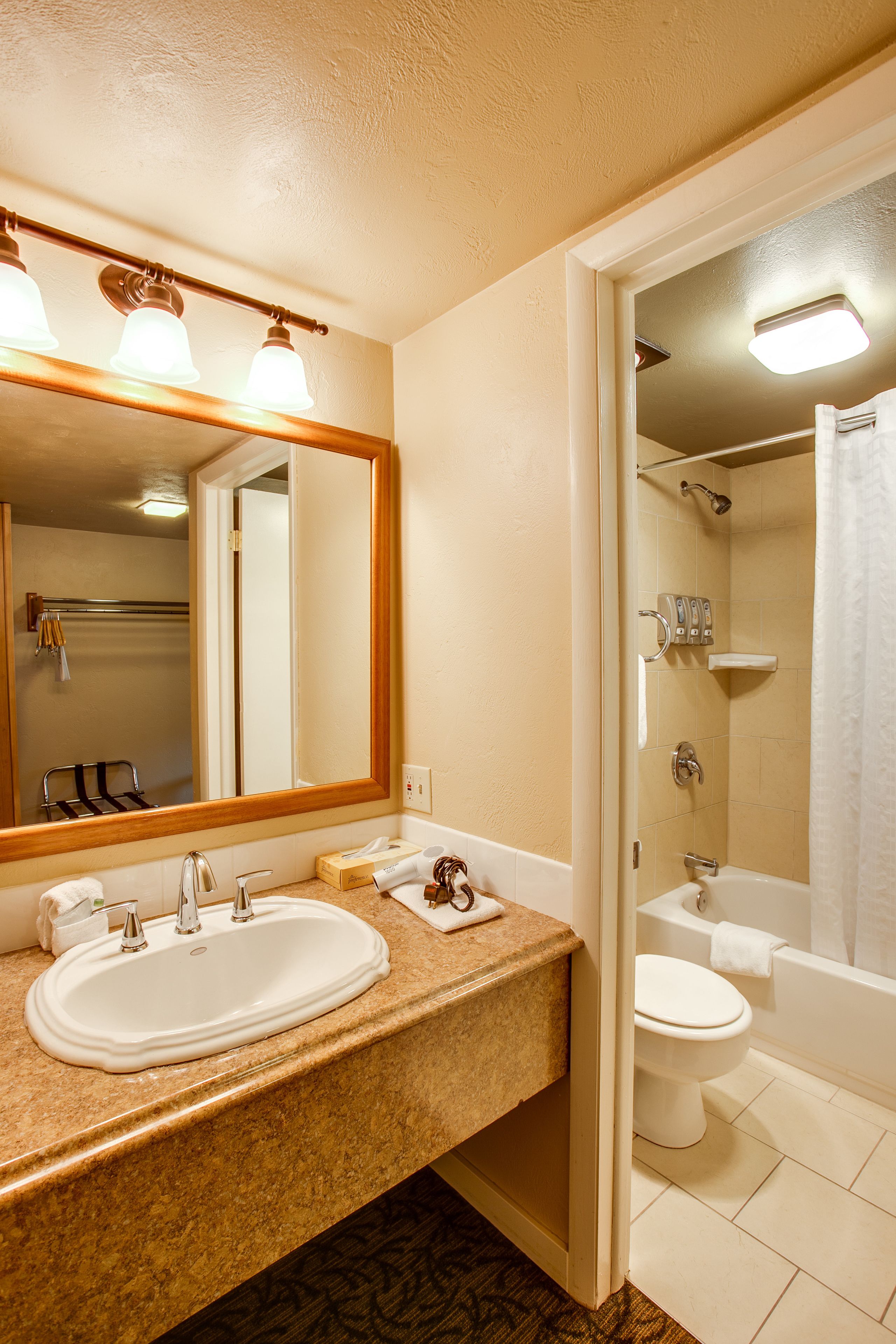 Un baño con dos lavamanos, un espejo, un inodoro y una zona de ducha.